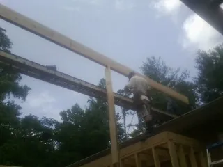 Carpenter setting a ridge beam over a new addition frame — Ice Dam Removal by Roofing Brothers in Charlotte Hall