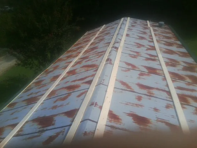 Rusted metal roof panels with new wood purlins before replacement — Storm Damage Roof Repair in Charlotte Hall by Roofing Brothers