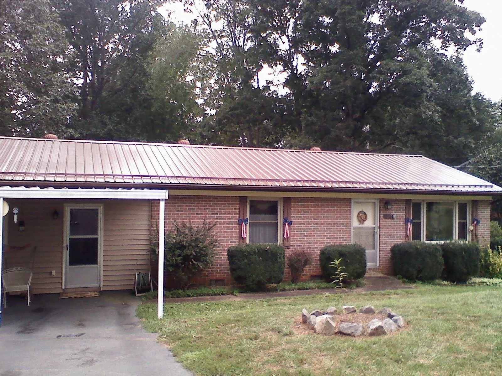 Bronze metal roof and carport on a brick ranch home — Roof Repair work by our crew in Charlotte Hall