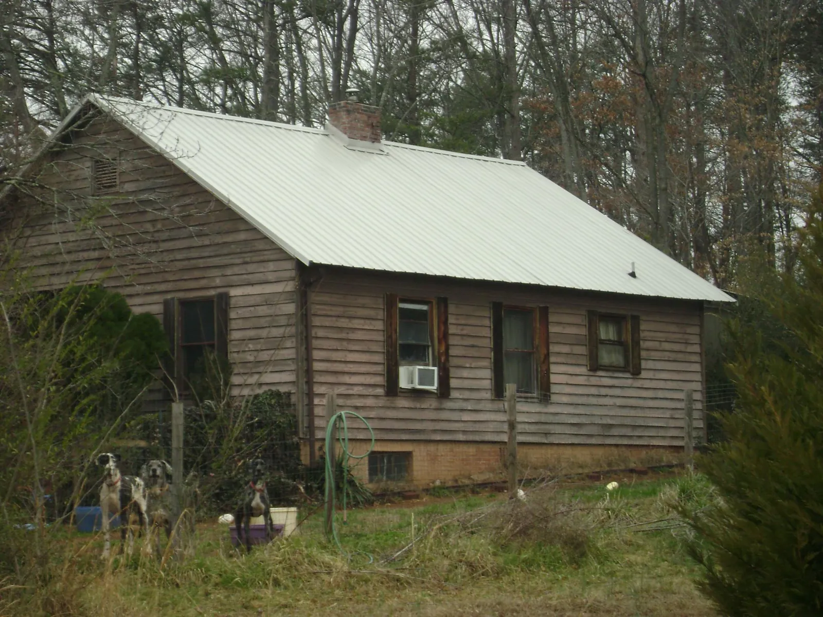 White metal roof on an old wood sided farmhouse, from a Metal Roof Installation job in Charlotte Hall